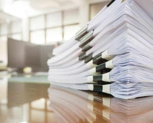 A stack of documents signifying the new registration requirements